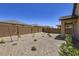 View of a low-maintenance backyard with gravel, desert landscaping, and block wall at 15018 W Buckskin Trl, Surprise, AZ 85387