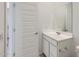 Bright bathroom with single sink vanity, mirror, and white door at 15018 W Buckskin Trl, Surprise, AZ 85387