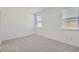 Bright bedroom with carpet, white walls, and two windows with blinds at 15018 W Buckskin Trl, Surprise, AZ 85387