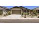 Single-story home featuring a two-car garage, desert landscaping, and a concrete driveway at 15018 W Buckskin Trl, Surprise, AZ 85387