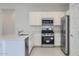 Well-equipped kitchen featuring stainless steel appliances, white cabinets, and efficient layout at 15018 W Buckskin Trl, Surprise, AZ 85387