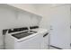 Bright laundry room with shelving, washer and dryer hookups, and white door at 15018 W Buckskin Trl, Surprise, AZ 85387