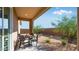 Inviting outdoor patio with stone flooring, a dining table, and well-maintained landscaping for comfortable outdoor living at 15018 W Buckskin Trl, Surprise, AZ 85387