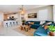 Inviting living room with a comfortable blue sectional sofa, a decorative rug, and an open view to the kitchen at 15060 W Hackamore Dr, Surprise, AZ 85387
