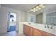 Bathroom featuring a dual sink vanity, large mirror, and access to an outdoor deck at 1851 W Vermont Ave, Phoenix, AZ 85015