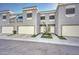 Modern townhouse exterior featuring gray stucco, white trim, individual garages, and tidy landscaping at 1851 W Vermont Ave, Phoenix, AZ 85015