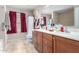 Bathroom featuring wood cabinets, double sinks, and a large mirror at 18525 W Valerie Dr, Surprise, AZ 85374