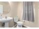 Cozy half bath featuring laminate flooring, a modern sink, and linen storage at 18525 W Valerie Dr, Surprise, AZ 85374