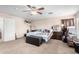 A comfortable primary bedroom showing an open closet, a ceiling fan, and carpet floors at 18525 W Valerie Dr, Surprise, AZ 85374