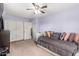 A secondary bedroom displaying a daybed, a ceiling fan, and a double-door closet at 18525 W Valerie Dr, Surprise, AZ 85374