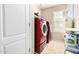 The laundry room has a front-load washer and dryer in a modern color at 18525 W Valerie Dr, Surprise, AZ 85374