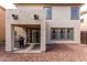 Covered patio with BBQ grill, sliding glass doors, and desert landscaping in the backyard at 18525 W Valerie Dr, Surprise, AZ 85374