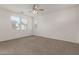 Bright bedroom with neutral carpet, ceiling fan, and large windows for natural light at 1857 W 22Nd Ave, Apache Junction, AZ 85120