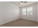 Bedroom featuring carpeted floors, a ceiling fan, and two windows for natural light at 1857 W 22Nd Ave, Apache Junction, AZ 85120