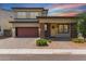 Charming two-story home featuring a red garage door, landscaped front yard, and covered porch at 1857 W 22Nd Ave, Apache Junction, AZ 85120