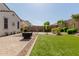 A spacious backyard with a well-manicured lawn, landscaping, brick pavers, and a desert landscaped area in the back at 20556 W Point Ridge Rd, Buckeye, AZ 85396