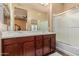 En-suite bathroom featuring a double sink vanity, and a shower-over-tub with sliding glass door at 20556 W Point Ridge Rd, Buckeye, AZ 85396
