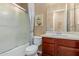 Cozy bathroom with wood vanity, mirror, and a shower-over-tub with frosted sliding shower doors at 20556 W Point Ridge Rd, Buckeye, AZ 85396
