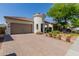 Charming single-story home with a turret entrance, attached two-car garage, well-maintained landscaping and a brick driveway at 20556 W Point Ridge Rd, Buckeye, AZ 85396