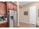 Spacious kitchen with stainless steel refrigerator, cherry cabinets, granite countertops and tile flooring at 20556 W Point Ridge Rd, Buckeye, AZ 85396