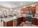 Well-lit kitchen featuring stainless steel appliances, tile flooring and backsplash, granite countertops and pendant lighting at 20556 W Point Ridge Rd, Buckeye, AZ 85396