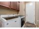 A well-lit laundry room with modern washer and dryer units and ample cabinet storage at 20556 W Point Ridge Rd, Buckeye, AZ 85396