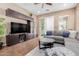 Comfortable living room with a large gray sectional sofa, a ceiling fan, tile flooring and built-in entertainment center at 20556 W Point Ridge Rd, Buckeye, AZ 85396