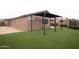 Spacious backyard features lush artificial turf and a modern pergola, ideal for outdoor entertaining at 21303 E Estrella Rd, Queen Creek, AZ 85142