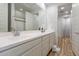 Well-lit bathroom showcases a double sink vanity with white cabinets and a large mirror, complemented by wood-look flooring at 21303 E Estrella Rd, Queen Creek, AZ 85142