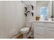 Clean bathroom includes shelving, wood countertop, and a toilet with a white curtained shower at 21303 E Estrella Rd, Queen Creek, AZ 85142