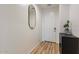 Bright entryway featuring wood-look floors, a modern mirror, and a white front door at 21303 E Estrella Rd, Queen Creek, AZ 85142