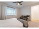 This lovely main bedroom features a ceiling fan and large window at 21303 E Estrella Rd, Queen Creek, AZ 85142