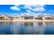 Exterior view of a waterfront property showing the backyard featuring gravel landscaping and a covered patio at 22206 N Daniel Dr, Maricopa, AZ 85138