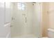 A tiled walk-in shower equipped with sleek glass doors and a window to let in natural light at 2315 N 52Nd St # 144, Phoenix, AZ 85008