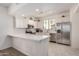 Bright kitchen features stainless steel appliances, white cabinets, subway tile backsplash, and a spacious quartz countertop island at 2315 N 52Nd St # 144, Phoenix, AZ 85008