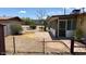 Residential backyard with a patio area, mature bushes, and chain-link fencing at 2414 W Cholla St, Phoenix, AZ 85029