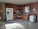 A full kitchen with a white refrigerator, oven, wood cabinets, and brick-like features at 2414 W Cholla St, Phoenix, AZ 85029