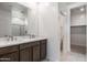 Bathroom featuring double sinks, marble counters, and a glass enclosed shower, providing a spa-like experience at 25096 N 154Th Ln, Surprise, AZ 85387