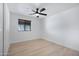 An empty room with light flooring, neutral walls, a ceiling fan, and a window with dark blinds at 2510 W Columbine Dr, Phoenix, AZ 85029