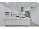 Stylish kitchen with white cabinets, stainless appliances, range hood, and large island with seating at 2510 W Columbine Dr, Phoenix, AZ 85029