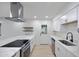 Well-lit kitchen boasts stainless appliances, white cabinetry, quartz counters, and a center island with cooktop at 2510 W Columbine Dr, Phoenix, AZ 85029