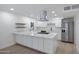 Bright, modern kitchen featuring white cabinetry, stainless steel appliances, and a spacious island with quartz countertops at 2510 W Columbine Dr, Phoenix, AZ 85029