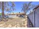 Spacious backyard, featuring a partially covered patio and mature trees, enclosed by a block wall at 2845 E Irwin Ave, Mesa, AZ 85204