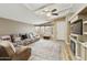 Open living room featuring a ceiling fan, fireplace, plush sofa, and large rug at 3301 S Goldfield Rd # 1010, Apache Junction, AZ 85119