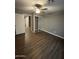 Bedroom with wood-look flooring, ceiling fan, closet with sliding doors, and neutral walls at 4049 N 81St Ave, Phoenix, AZ 85033