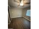 Bedroom features hardwood flooring, ceiling fan, mirrored closet and window at 4049 N 81St Ave, Phoenix, AZ 85033