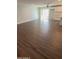 Spacious open-concept living room area with hardwood flooring, fan, and sliding glass doors to the outside at 4049 N 81St Ave, Phoenix, AZ 85033