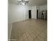 Spacious living room with neutral tile flooring, ceiling fan, and stainless steel refrigerator at 4049 N 81St Ave, Phoenix, AZ 85033