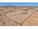 Vast parcel featuring a modest house, outbuildings, and sizable flat land surrounded by mountain views at 43384 W Padilla Rd, Maricopa, AZ 85138