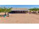 Exterior view of a property featuring covered parking, a shed, and ample yard space at 43384 W Padilla Rd, Maricopa, AZ 85138
